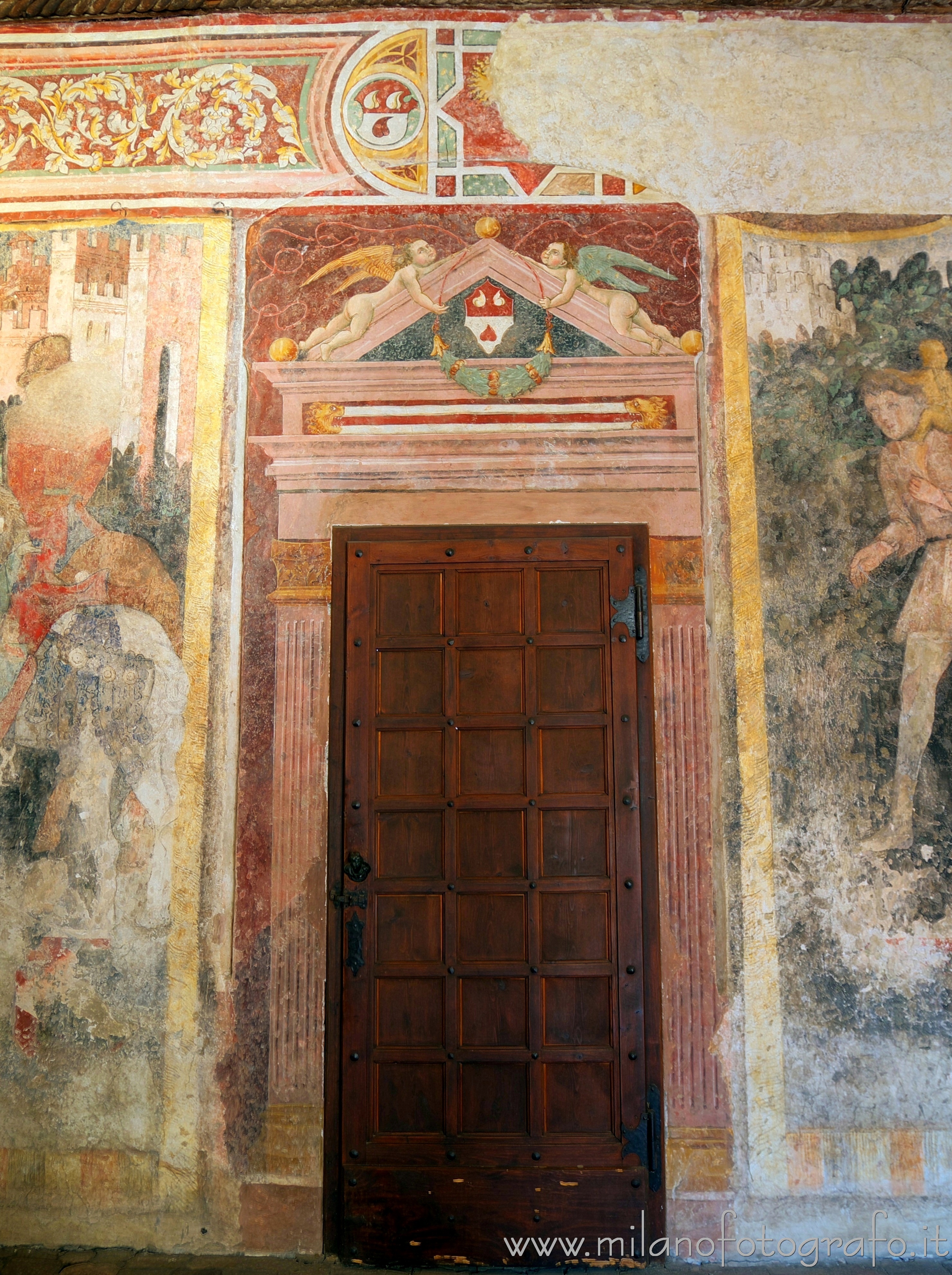 Cavernago (Bergamo, Italy) - Door surrounded by frescoes in the court of the Malpaga Castle